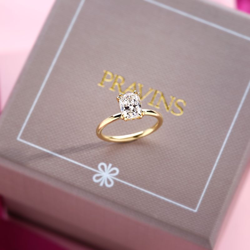 18ct yellow gold solitaire engagement ring with an elongated cushion cut diamond and hidden diamond halo, displayed on a Pravins jewellery box.